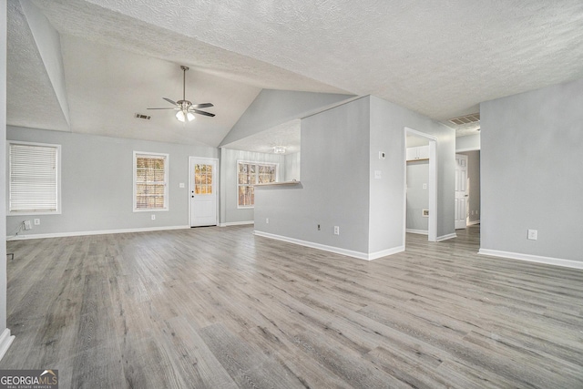 unfurnished living room featuring ceiling fan, lofted ceiling, and hardwood / wood-style floors