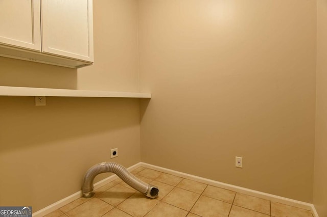 washroom with cabinets, electric dryer hookup, and light tile patterned floors