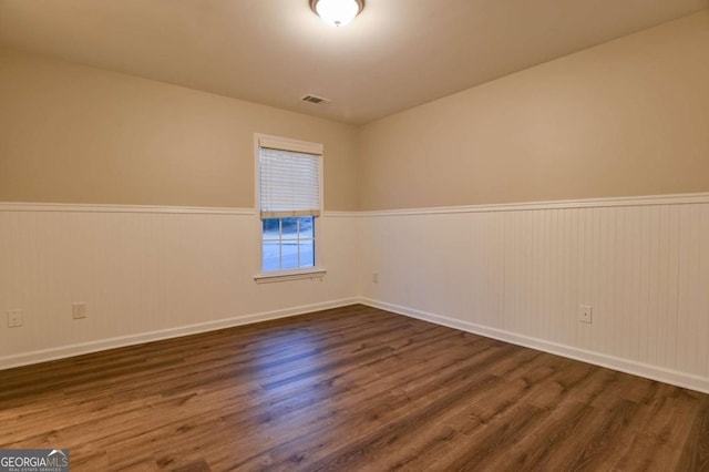 unfurnished room with dark wood-type flooring