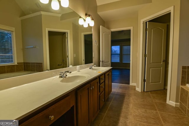 bathroom featuring tiled tub, vanity, and tile patterned floors