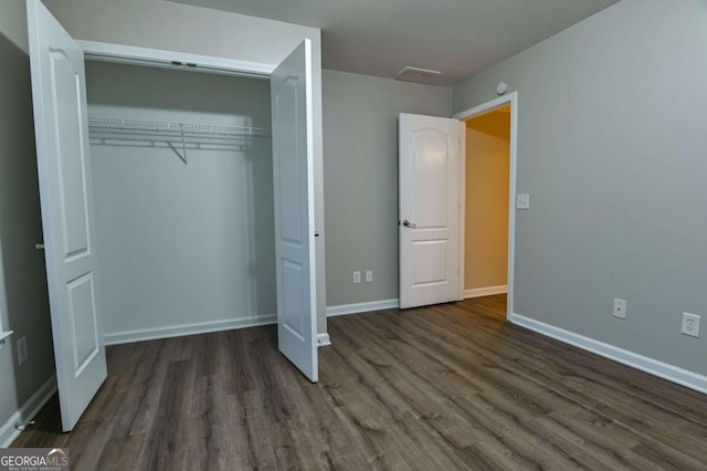 unfurnished bedroom featuring dark hardwood / wood-style flooring and a closet