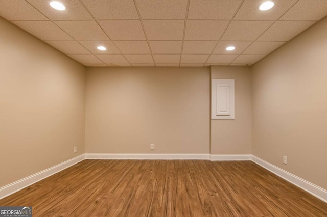 empty room featuring wood-type flooring and a paneled ceiling