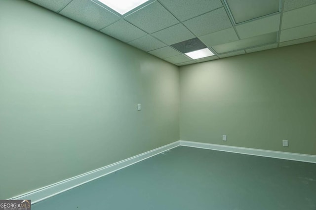 unfurnished room with a paneled ceiling and concrete floors