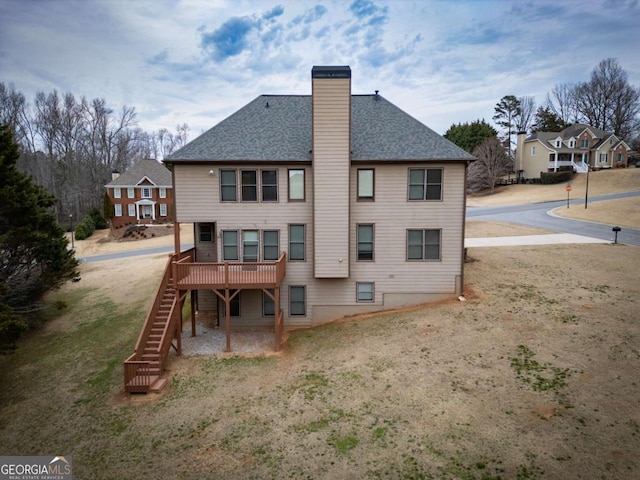 back of property with a wooden deck and a lawn