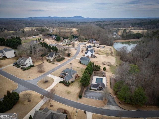 birds eye view of property with a water and mountain view