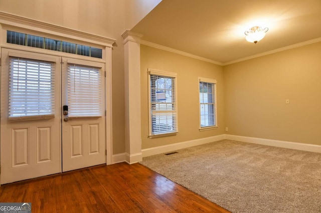 entrance foyer featuring ornamental molding, dark hardwood / wood-style flooring, and decorative columns