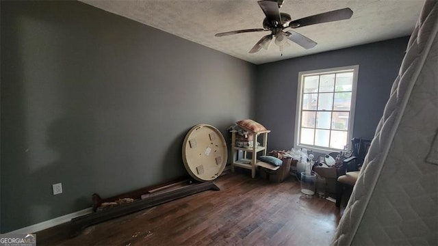 misc room featuring ceiling fan, hardwood / wood-style floors, and a textured ceiling