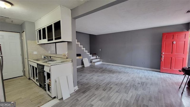 kitchen featuring backsplash, light hardwood / wood-style floors, and sink