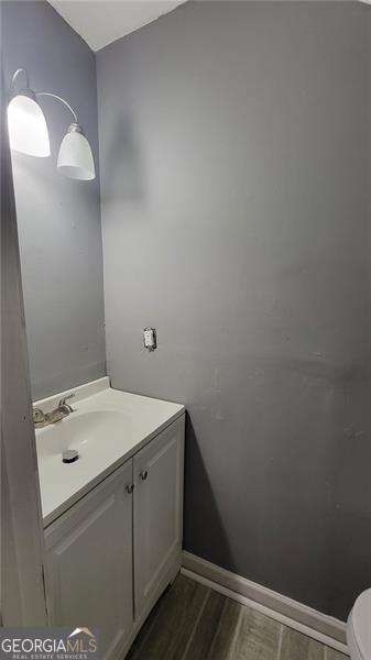 bathroom with vanity, toilet, and hardwood / wood-style floors