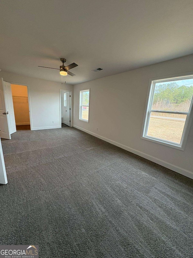 empty room with dark carpet and ceiling fan