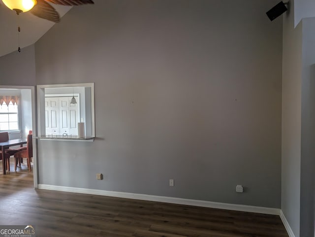 spare room with ceiling fan, dark wood-type flooring, and high vaulted ceiling