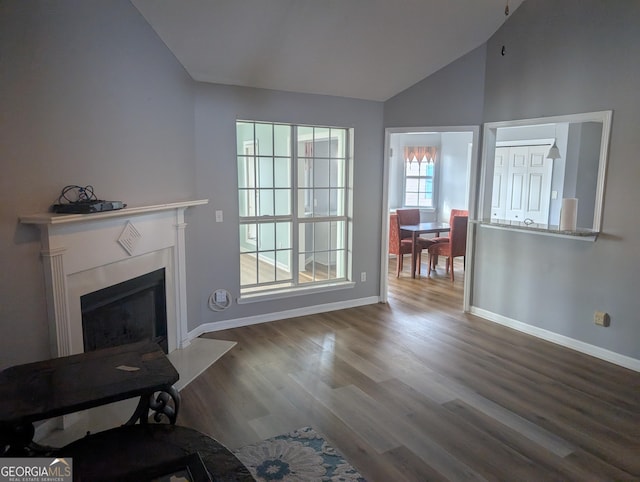 unfurnished living room featuring vaulted ceiling and dark hardwood / wood-style floors