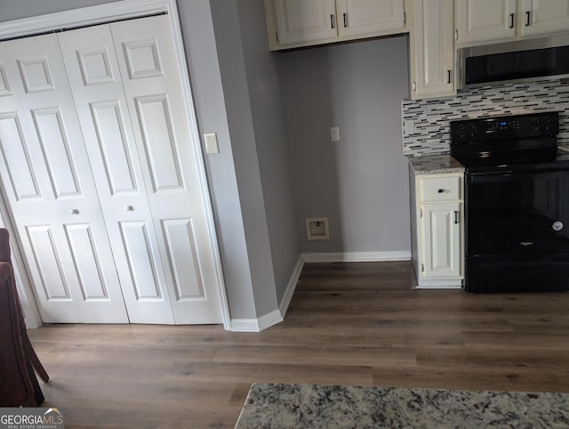 kitchen featuring dark hardwood / wood-style flooring, black range with electric stovetop, backsplash, and light stone countertops