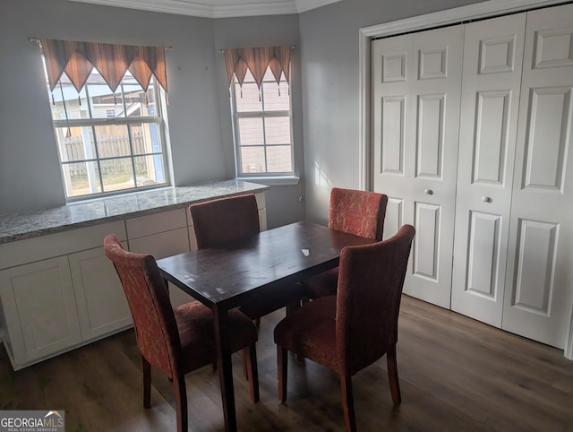 dining area with crown molding and dark wood-type flooring