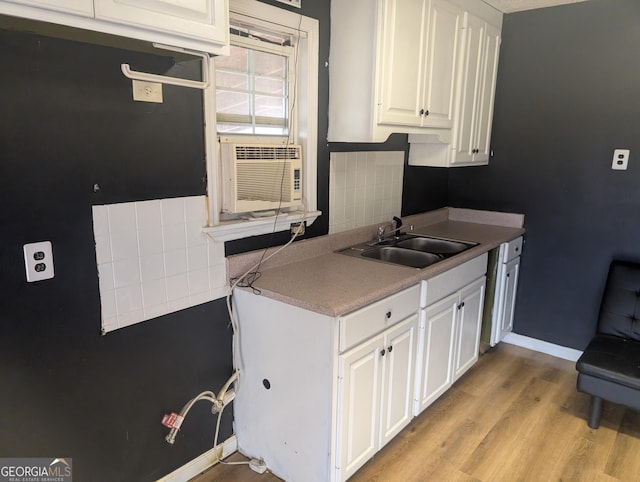 kitchen featuring sink, cooling unit, light hardwood / wood-style floors, decorative backsplash, and white cabinets