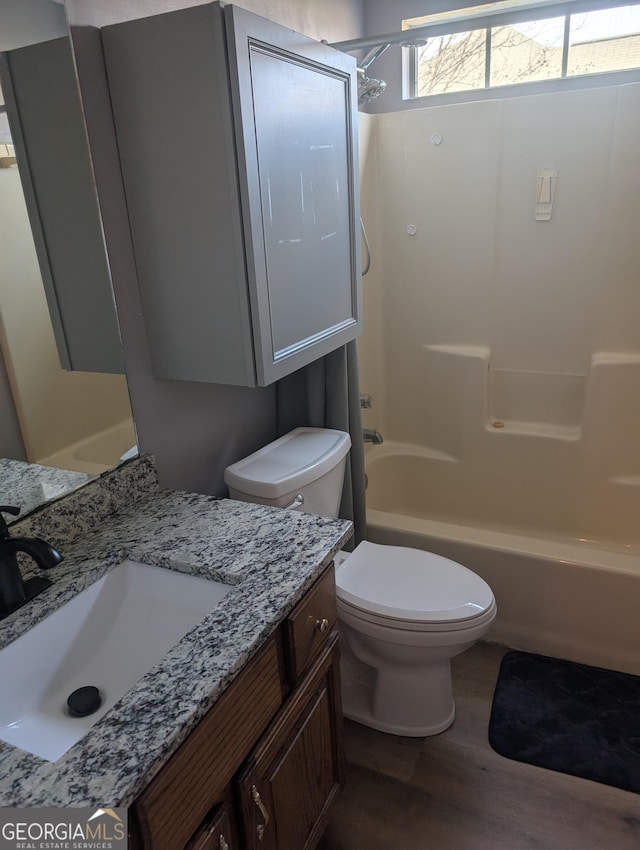 full bathroom featuring vanity, hardwood / wood-style floors, bathtub / shower combination, and toilet