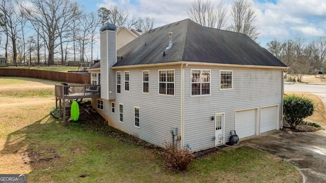 view of side of property featuring a garage, a deck, and a lawn