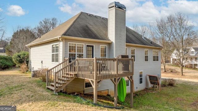 back of property with a wooden deck and a lawn