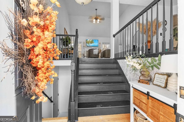 stairway featuring ceiling fan