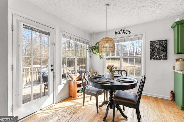 dining area featuring a textured ceiling and light hardwood / wood-style floors