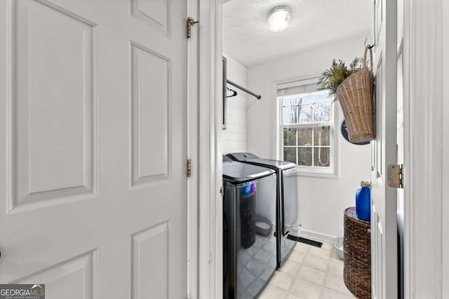 washroom featuring washing machine and dryer and a textured ceiling