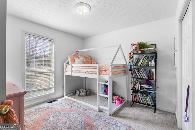 bedroom featuring a textured ceiling and carpet