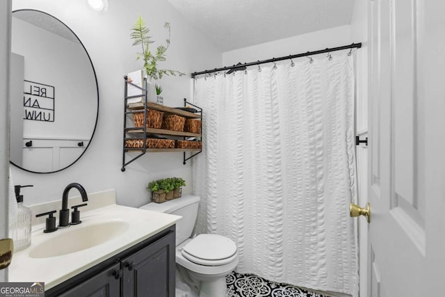 bathroom with vanity, toilet, and a textured ceiling