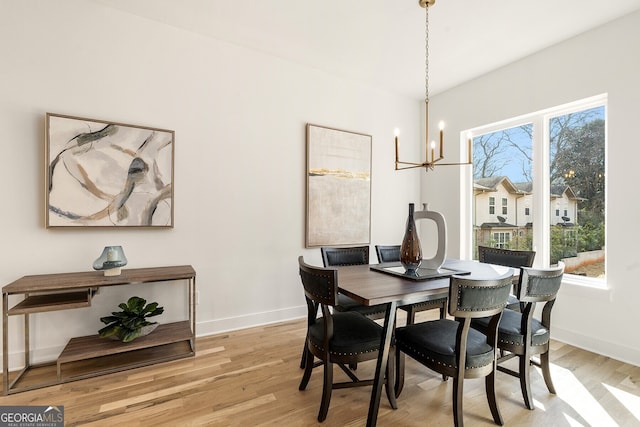 dining space with a notable chandelier and light hardwood / wood-style floors