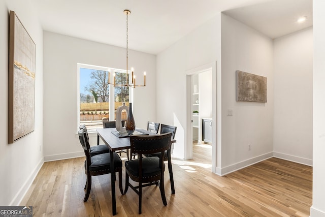 dining area with an inviting chandelier and light wood-type flooring