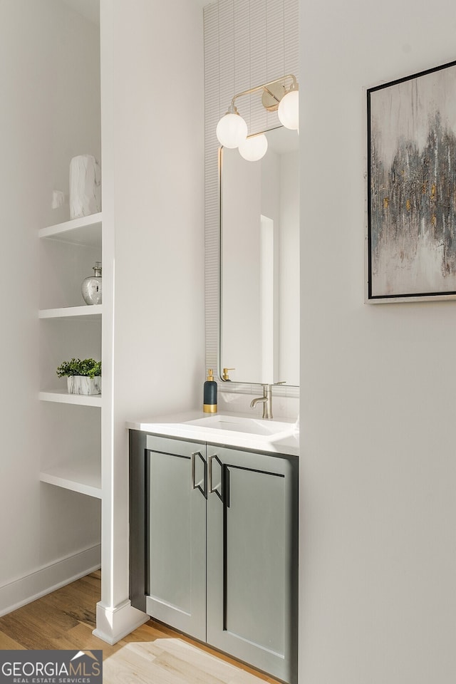 bathroom featuring built in features, wood-type flooring, and vanity