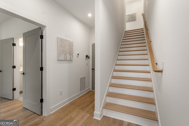 stairs featuring hardwood / wood-style flooring