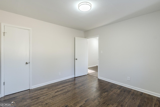 spare room with dark wood-type flooring