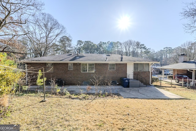 rear view of property with a patio and a lawn