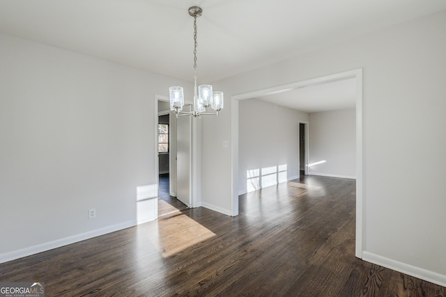 unfurnished dining area featuring an inviting chandelier and dark hardwood / wood-style floors