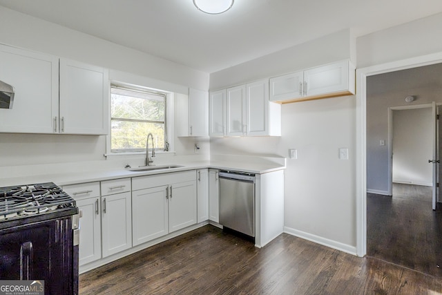 kitchen with dark wood-type flooring, appliances with stainless steel finishes, sink, and white cabinets