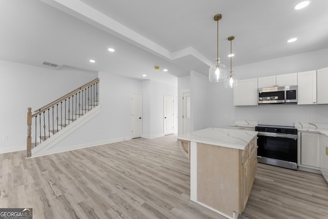 kitchen featuring light stone counters, hanging light fixtures, range with electric stovetop, a kitchen island, and white cabinets