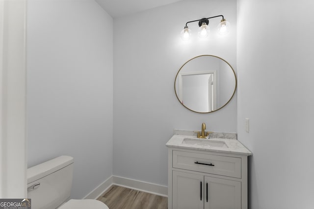 bathroom featuring hardwood / wood-style flooring, vanity, and toilet