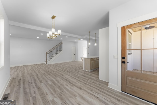 unfurnished living room with a chandelier and light hardwood / wood-style floors