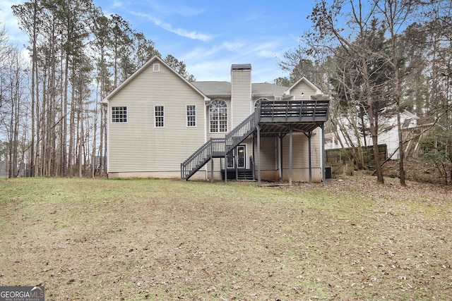 rear view of house with a wooden deck and a lawn