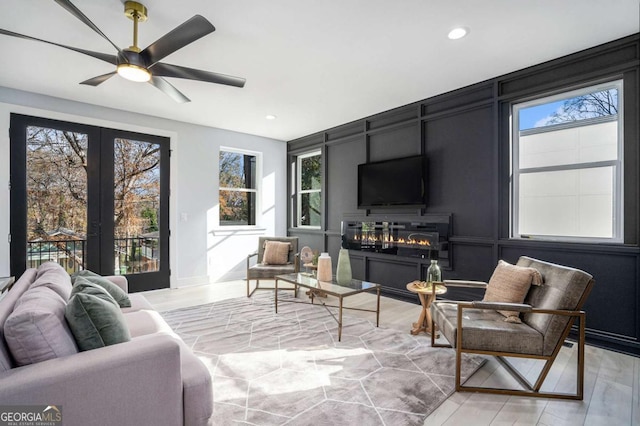 living room featuring ceiling fan and french doors