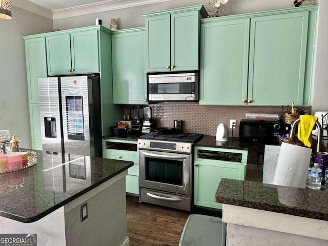 kitchen featuring crown molding, dark stone counters, dark hardwood / wood-style flooring, stainless steel appliances, and decorative backsplash