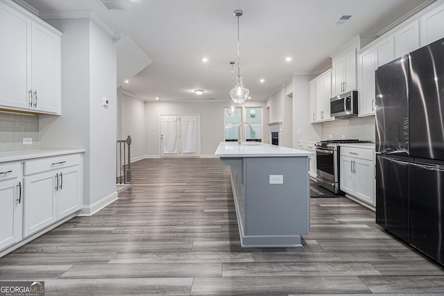 kitchen with white cabinetry, pendant lighting, stainless steel appliances, and an island with sink