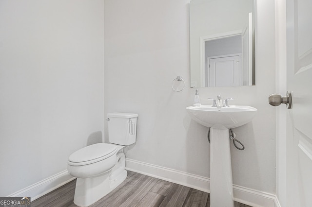 bathroom featuring hardwood / wood-style flooring and toilet