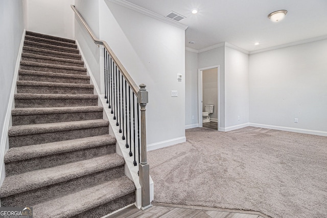 stairs featuring crown molding and carpet