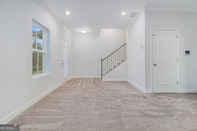 carpeted entrance foyer featuring ornamental molding