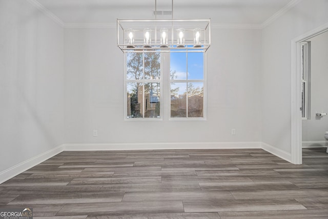 unfurnished dining area featuring dark hardwood / wood-style flooring, a notable chandelier, and crown molding