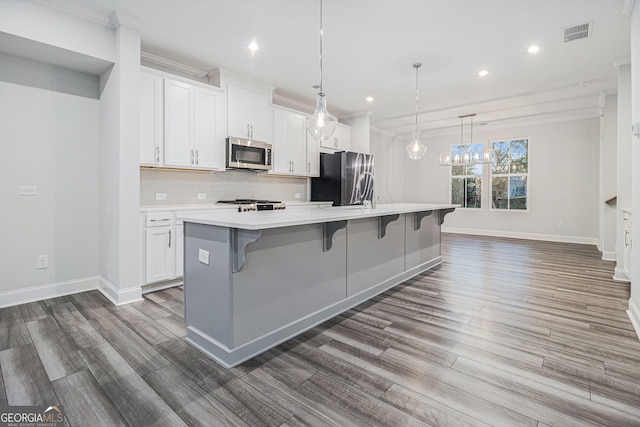 kitchen featuring stainless steel appliances, white cabinetry, and a large island