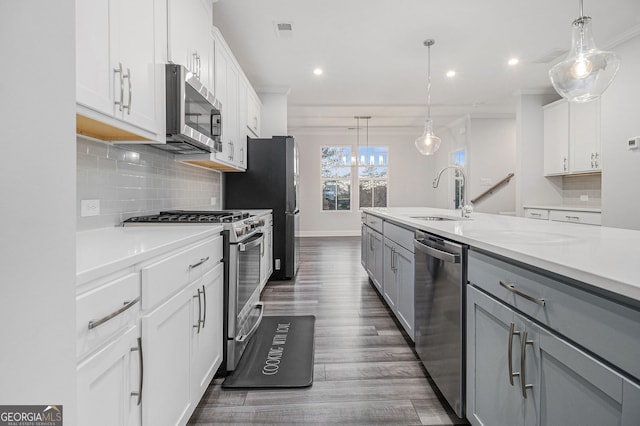 kitchen with white cabinetry, hanging light fixtures, stainless steel appliances, and gray cabinetry