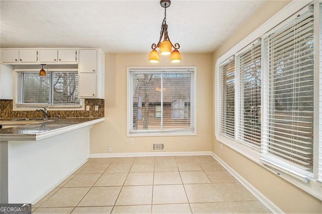 unfurnished dining area featuring light tile patterned floors and sink