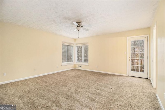 carpeted spare room featuring ceiling fan and a textured ceiling